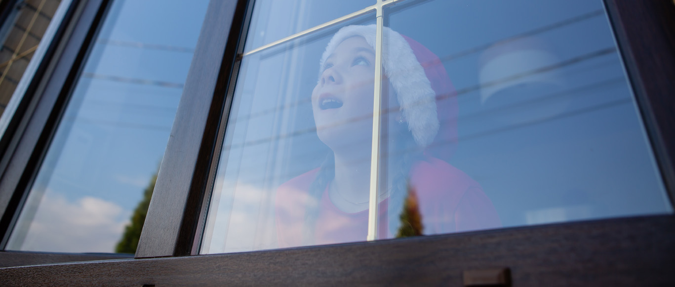 Child looking out through a residential window, highlighting the importance of energy-efficient window replacement in Corona, CA.