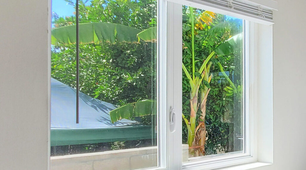 Energy-efficient sliding window with clear glass overlooking greenery at a home in Corona, CA.