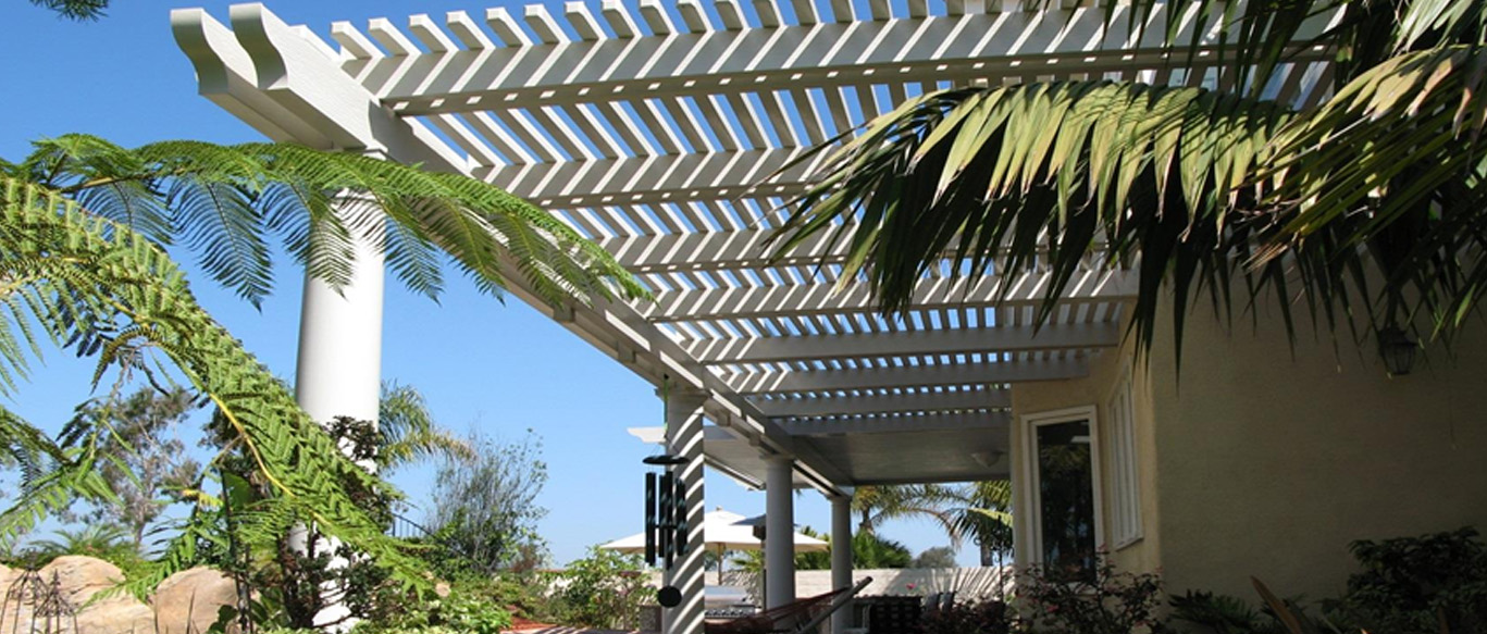 White pergola-style patio cover installed over a backyard patio at a home in Riverside, CA.