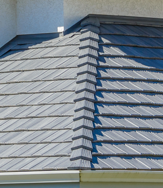 Gray tile roof with ridge caps on a residential home
