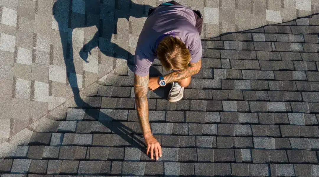 Roof inspector checking asphalt shingles before solar panel installation