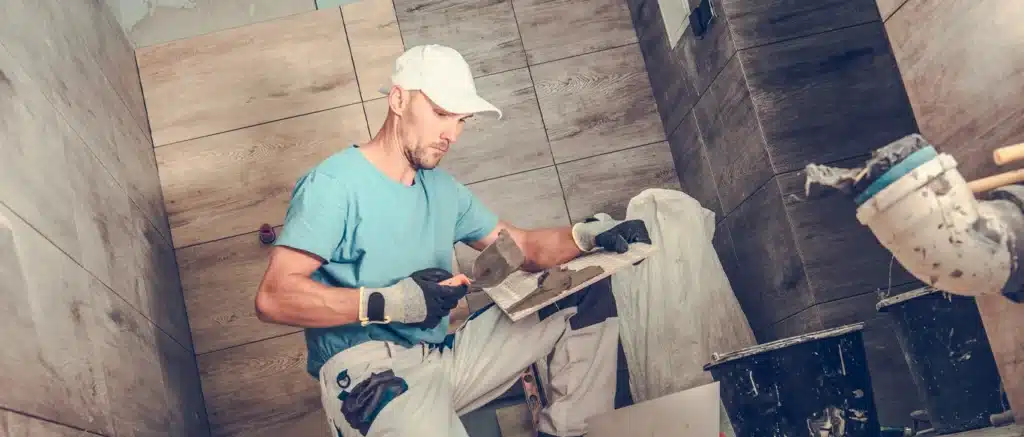 Bathroom remodeling contractor installing wood-look tile on a shower wall in the Inland Empire