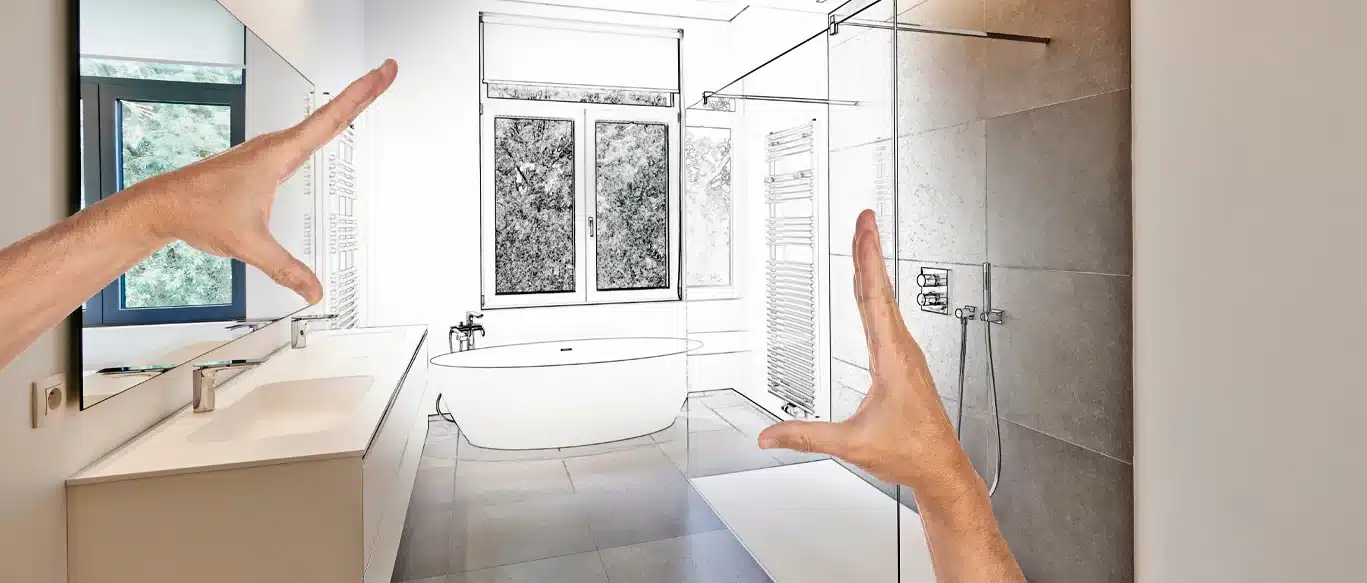 Hands framing a modern bathroom with a glass walk-in shower, freestanding tub, large tile, and long vanity.